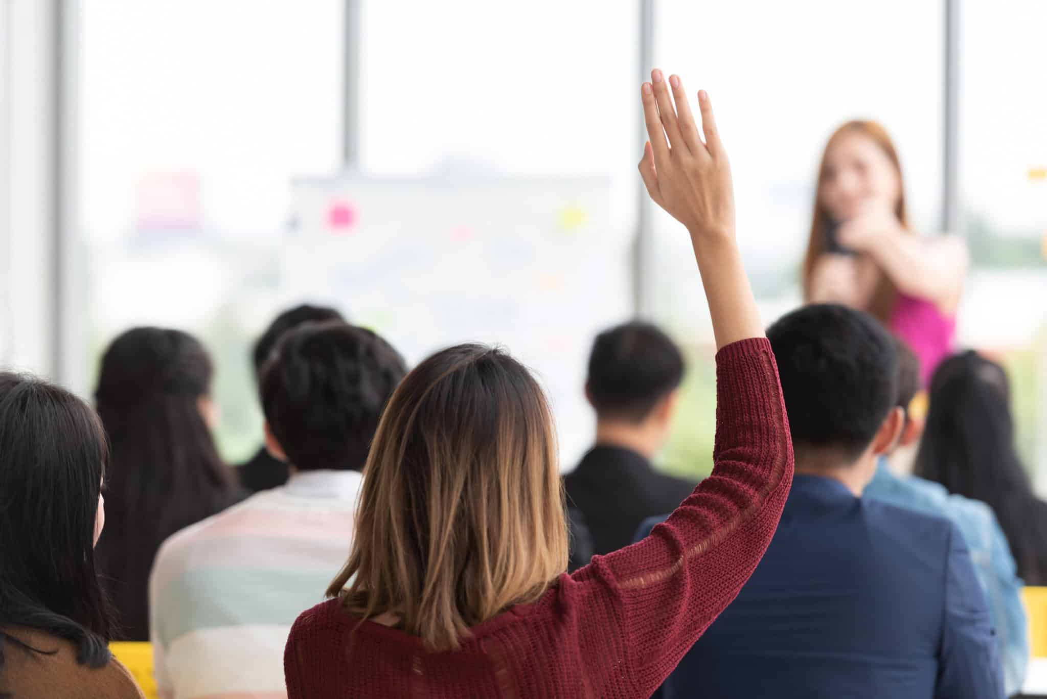 Student Raising Hand Up in a classroom